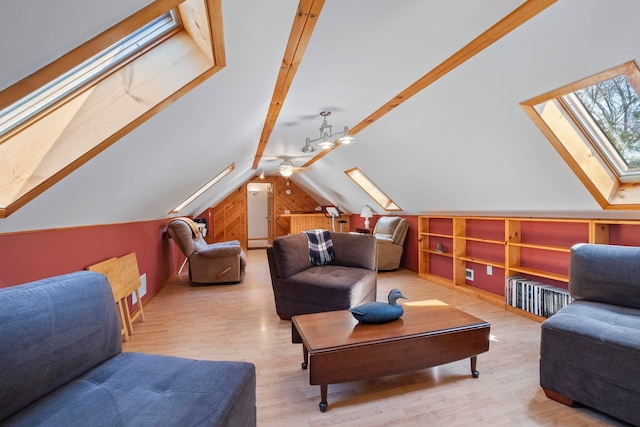 7734 N Shore Ct, Grawn, MI 49637 - sitting room with vaulted ceiling with skylight, built in features, a ceiling fan, and wood finished floors