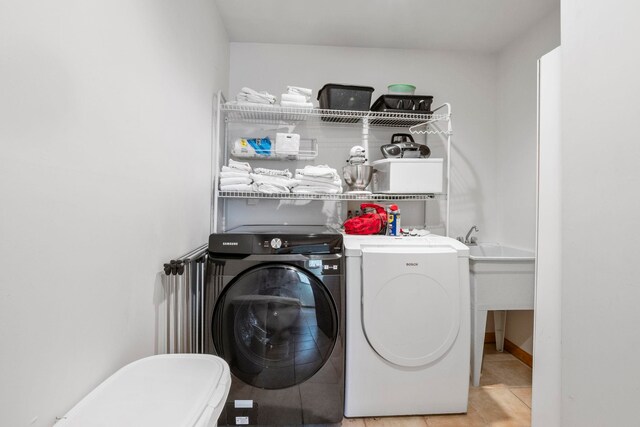 7734 N Shore Ct, Grawn, MI 49637 - washroom with separate washer and dryer, laundry area, and light tile patterned floors