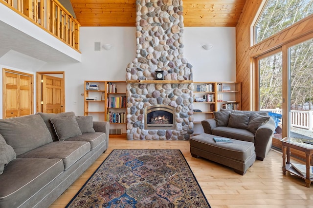 7734 N Shore Ct, Grawn, MI 49637 - living room featuring a fireplace, high vaulted ceiling, wooden ceiling, and hardwood / wood-style floors