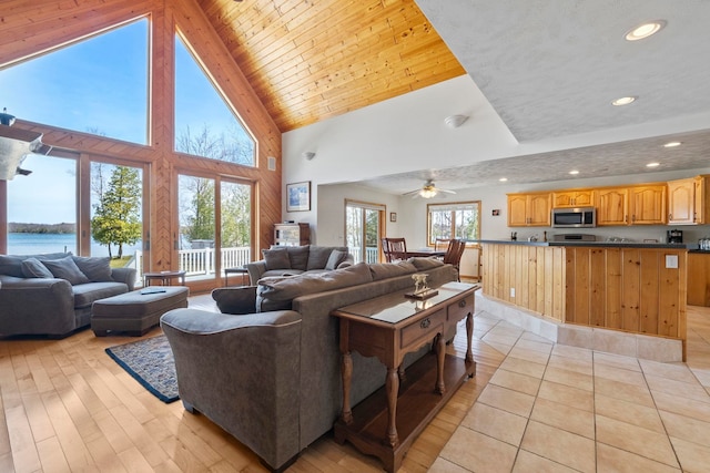 7734 N Shore Ct, Grawn, MI 49637 - living room with light wood-type flooring, recessed lighting, a water view, and high vaulted ceiling