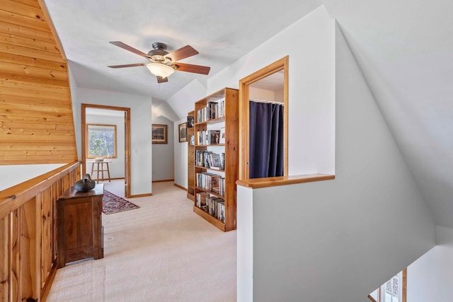 7734 N Shore Ct, Grawn, MI 49637 - hallway with wood walls, an upstairs landing, and light carpet