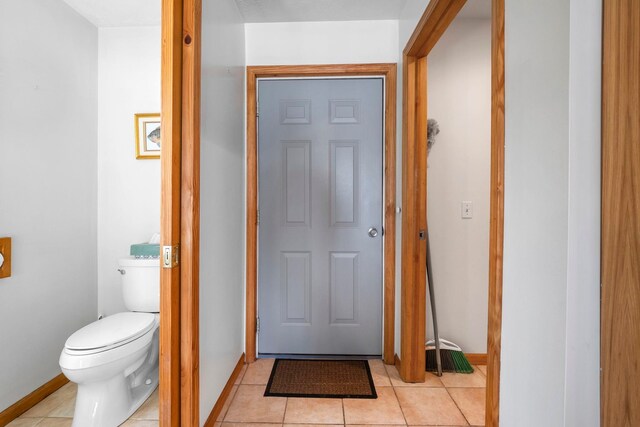 7734 N Shore Ct, Grawn, MI 49637 - bathroom featuring baseboards, tile patterned flooring, and toilet