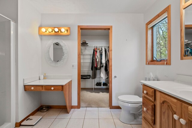 7734 N Shore Ct, Grawn, MI 49637 - bathroom featuring vanity, tile patterned floors, toilet, and a walk in closet