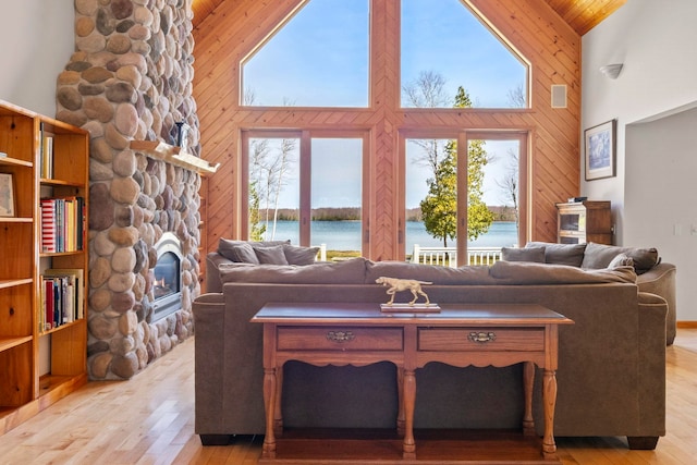 7734 N Shore Ct, Grawn, MI 49637 - living room with light wood-style floors, a fireplace, and high vaulted ceiling