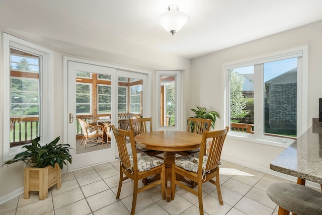 dining space featuring light tile patterned floors and baseboards