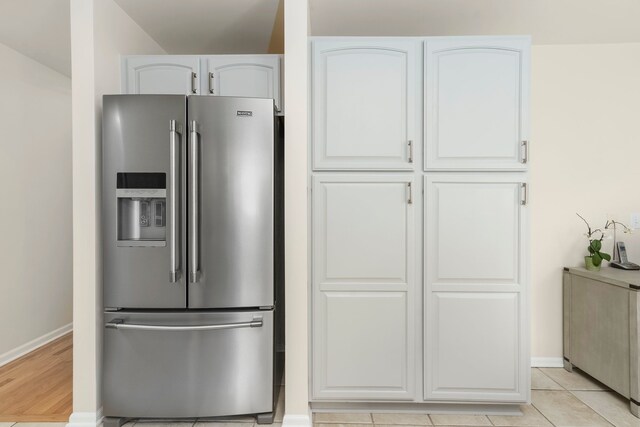 kitchen featuring white cabinets, baseboards, and stainless steel fridge with ice dispenser