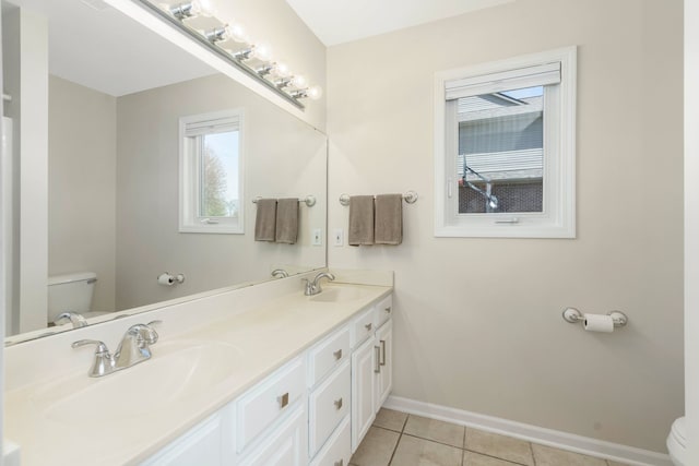 bathroom with baseboards, a sink, tile patterned flooring, and toilet