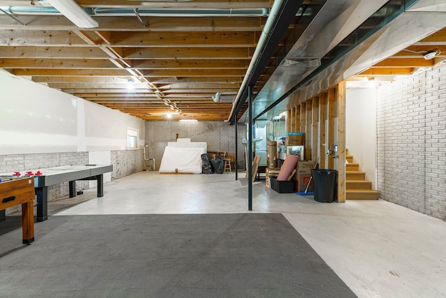 unfinished basement with stairs and brick wall
