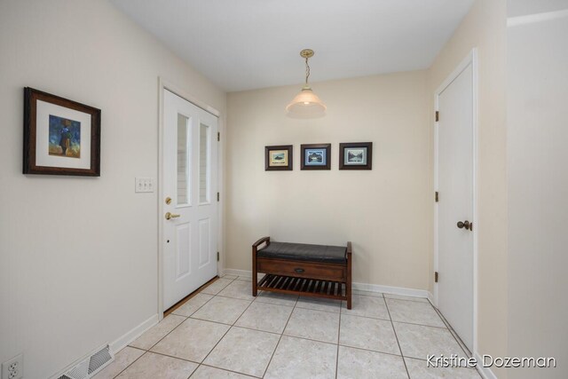 doorway featuring light tile patterned floors, baseboards, and visible vents