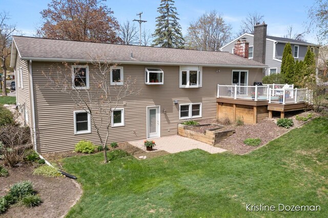rear view of house with a wooden deck and a yard
