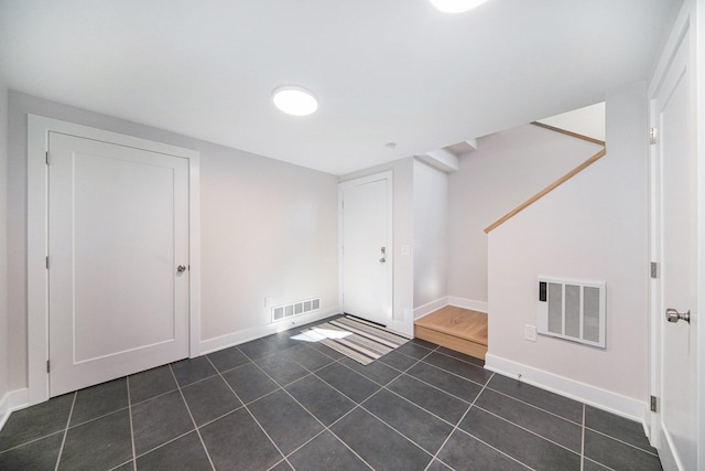 interior space with stairs, tile patterned floors, visible vents, and baseboards