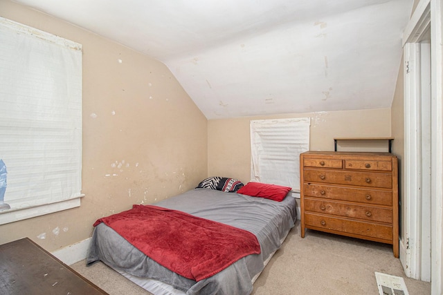 carpeted bedroom with vaulted ceiling and visible vents