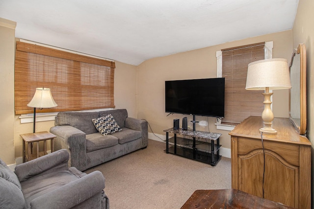 living area featuring carpet floors, baseboards, and lofted ceiling