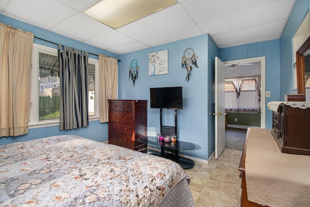 bedroom featuring baseboards and a drop ceiling