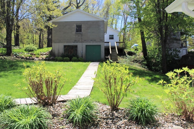 view of side of home featuring stairs, a wooden deck, and a yard