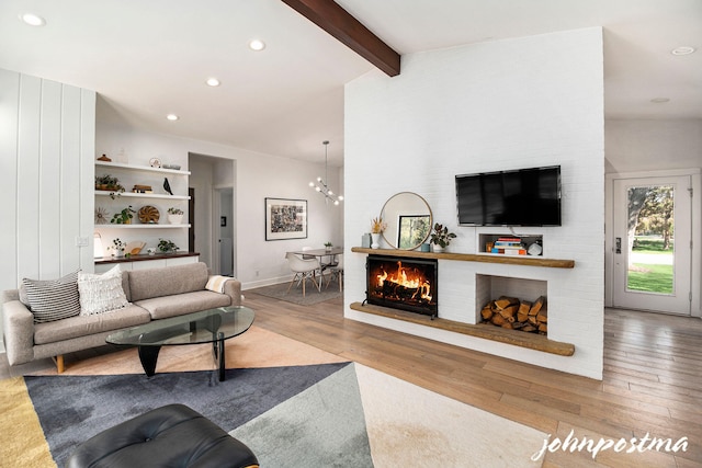 living room with a fireplace, a chandelier, recessed lighting, vaulted ceiling with beams, and wood finished floors