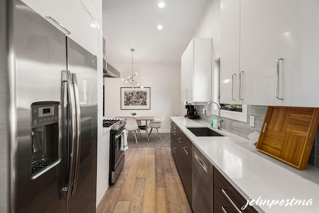 kitchen with dark brown cabinets, appliances with stainless steel finishes, a sink, and modern cabinets