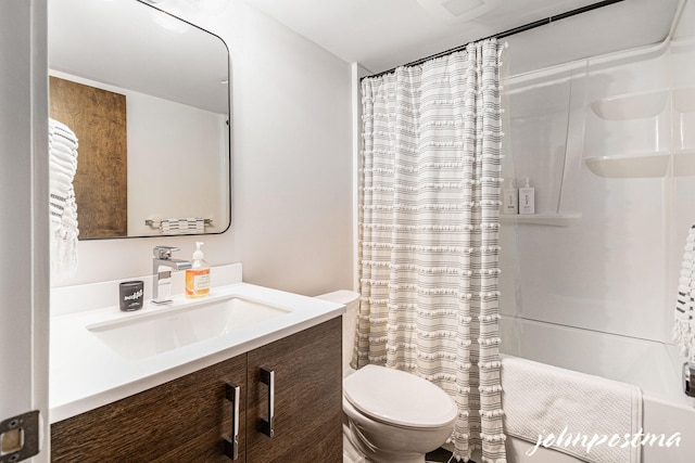 bathroom with vanity, shower / tub combo with curtain, and toilet