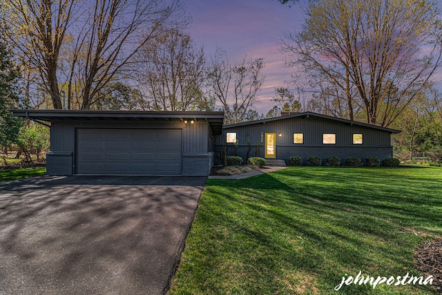 view of front facade featuring a detached garage, a lawn, and an outdoor structure