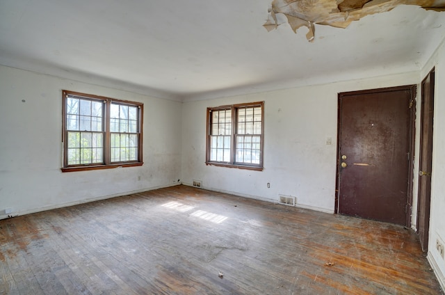 empty room with visible vents and hardwood / wood-style floors