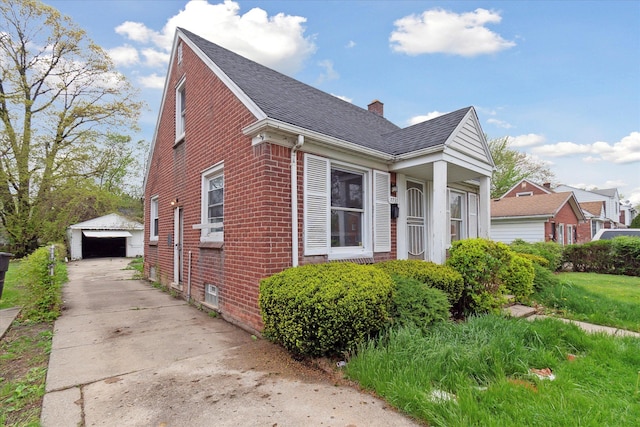 view of side of home featuring brick siding, an outdoor structure, a detached garage, a chimney, and roof with shingles