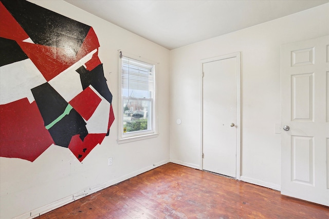 unfurnished bedroom with wood finished floors and baseboards