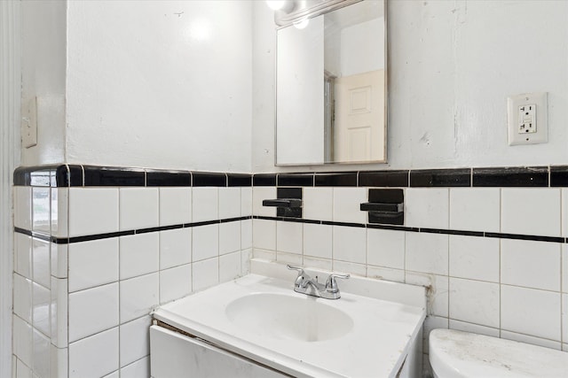 bathroom with tile walls, toilet, and vanity
