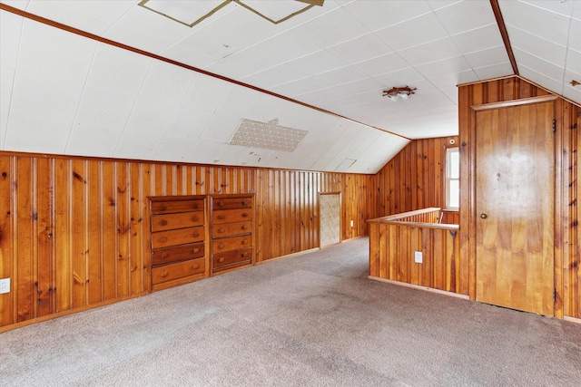 additional living space featuring vaulted ceiling, carpet floors, and wooden walls
