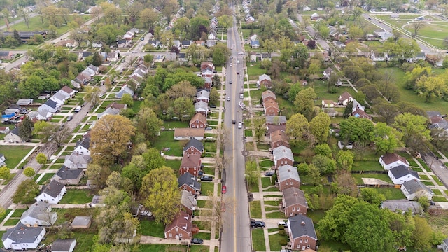 aerial view of property's location featuring nearby suburban area and a tree filled landscape