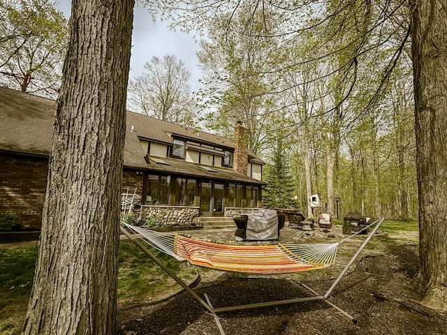 55535 Woody Ln, South Lyon, MI 48178 - back of house with a shingled roof, a patio, and a chimney