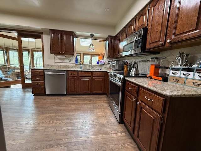 55535 Woody Ln, South Lyon, MI 48178 - kitchen with appliances with stainless steel finishes, decorative backsplash, wood finished floors, and a sink