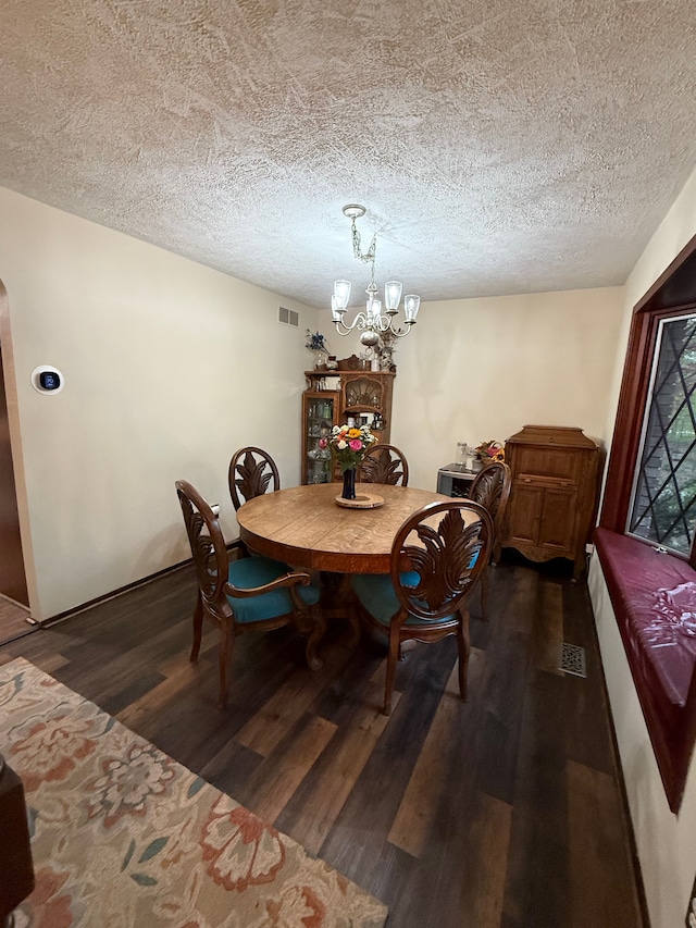 55535 Woody Ln, South Lyon, MI 48178 - dining area featuring dark wood-type flooring, a chandelier, and a textured ceiling
