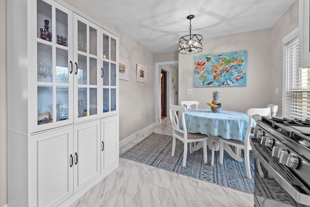 dining space with marble finish floor and a notable chandelier