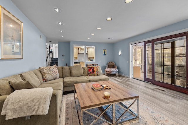 living area with visible vents, stairs, baseboards, recessed lighting, and light wood-style flooring