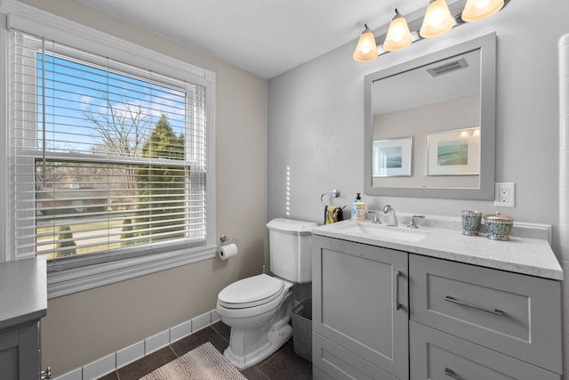 bathroom featuring plenty of natural light, visible vents, toilet, and vanity
