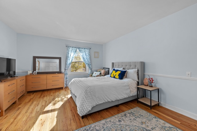 bedroom with baseboards and light wood finished floors