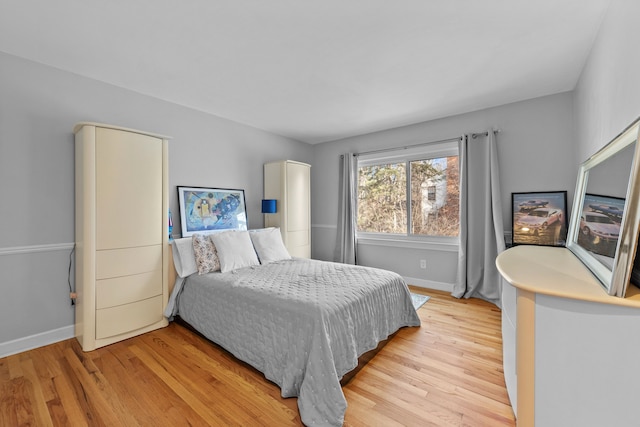 bedroom with baseboards and light wood-style flooring