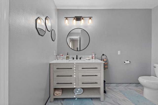 bathroom featuring vanity, marble finish floor, and toilet