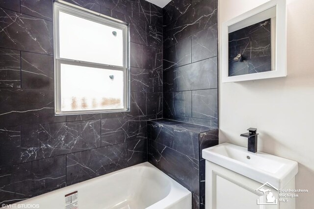 bathroom with plenty of natural light, bathing tub / shower combination, and vanity