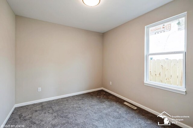 carpeted empty room with visible vents and baseboards