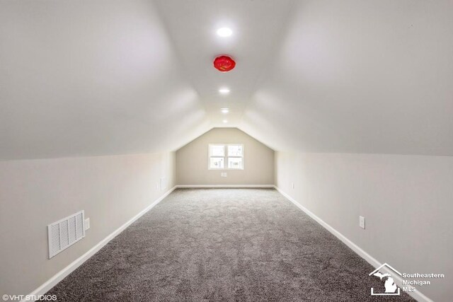 bonus room with baseboards, vaulted ceiling, carpet floors, and visible vents