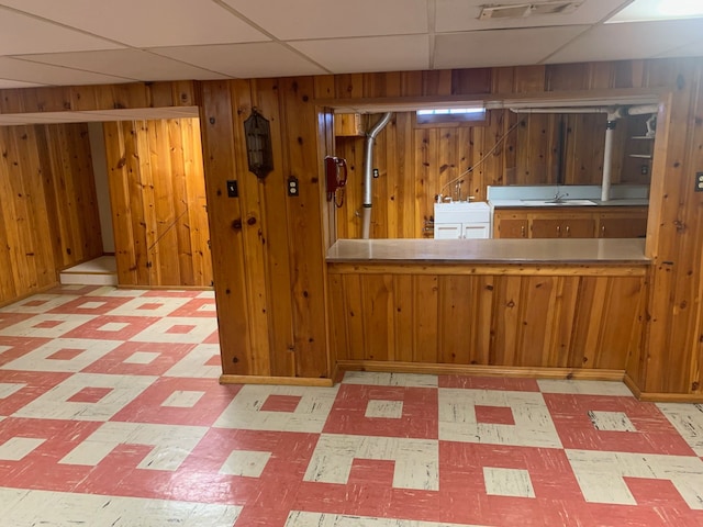 interior space with visible vents, wood walls, a paneled ceiling, tile patterned floors, and a sink