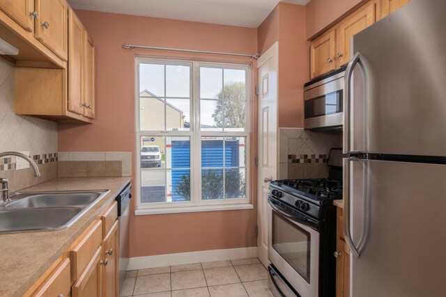 kitchen featuring a sink, appliances with stainless steel finishes, a wealth of natural light, and light countertops