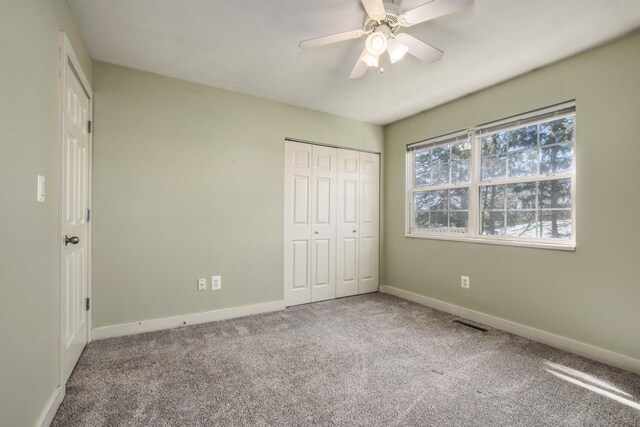 unfurnished bedroom with a closet, baseboards, ceiling fan, and carpet flooring