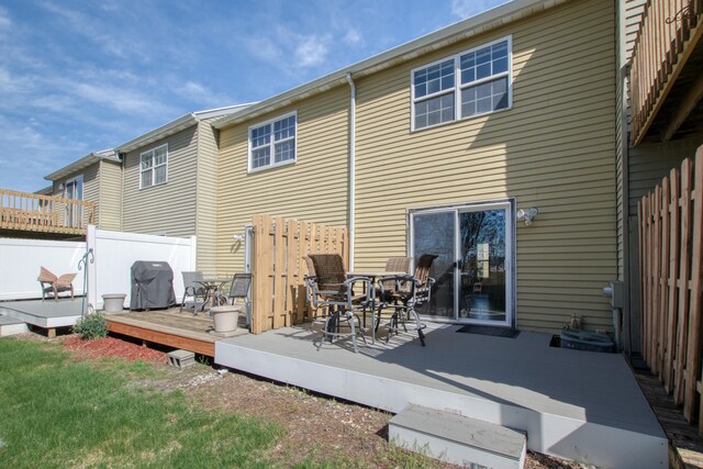 back of property featuring fence, outdoor dining space, and a deck