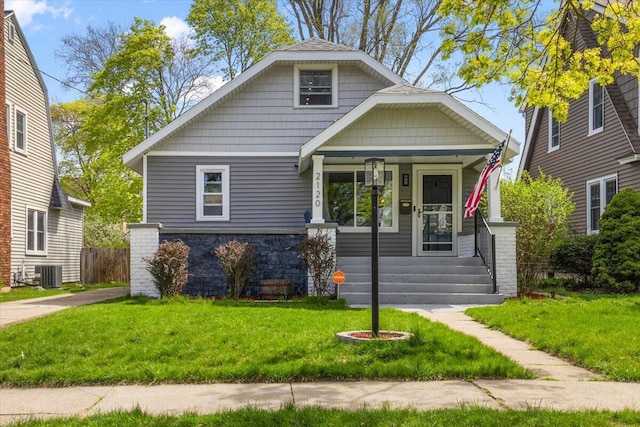 bungalow featuring a front lawn, central AC, and covered porch