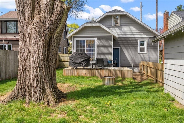 rear view of house featuring a fenced backyard and a yard