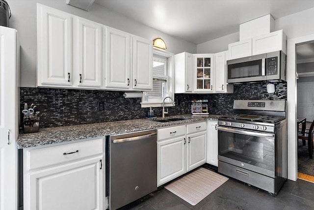 kitchen featuring a sink, appliances with stainless steel finishes, white cabinets, and backsplash