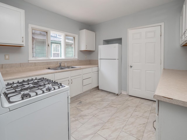 kitchen with a sink, marble finish floor, white appliances, and light countertops