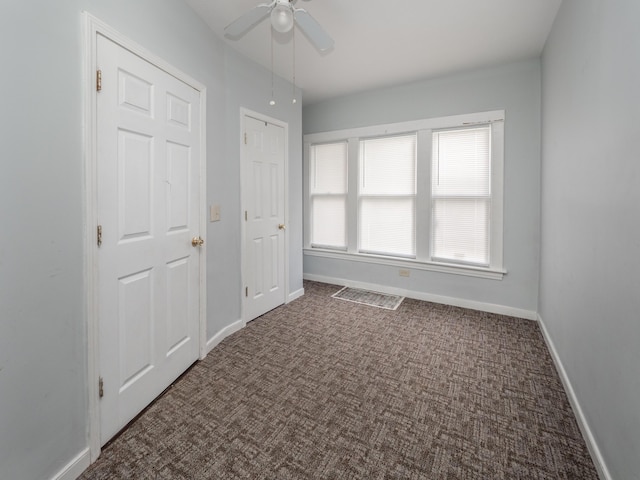 unfurnished bedroom with carpet flooring, a ceiling fan, and baseboards